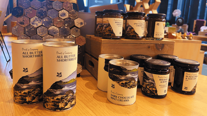Selection of butter shortbreads, jams, chutneys and mint creams from the exclusive Giant's Causeway range, displayed in the Retail area of the Visitor Centre, with a range of signature hexagonal magnets on display in the background